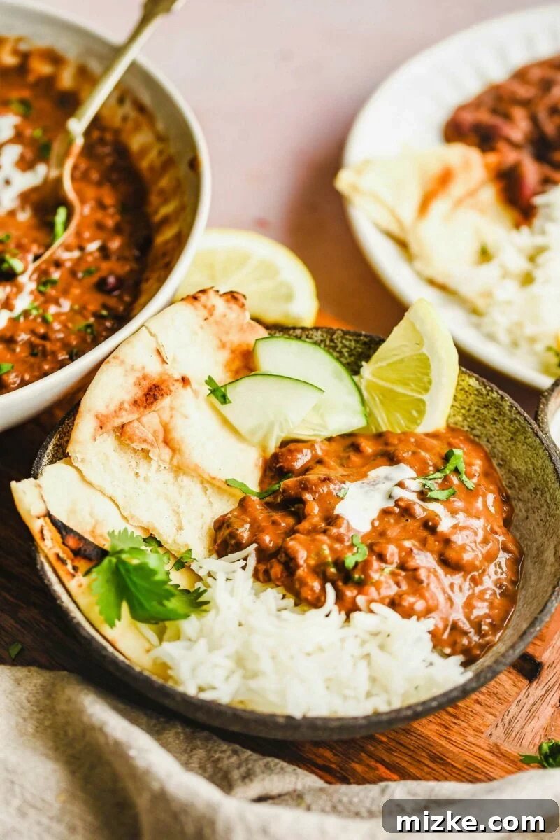 A bowl is filled with dal makhani and sides.