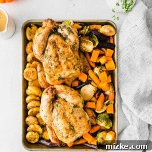 Sheet Pan Thanksgiving: Minimal Effort, Maximum Flavor 7 A close-up of a perfectly cooked sheet pan Thanksgiving dinner, featuring golden-brown Cornish hens, crispy smashed potatoes, and roasted vegetables, garnished with fresh herbs.