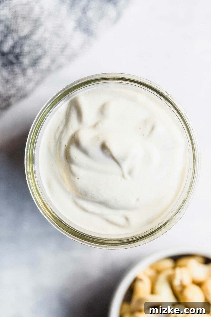 Dreamy Vegan Cashew Cream 3 The top view of a glass mason jar filled with a thick, white cashew cream sauce.