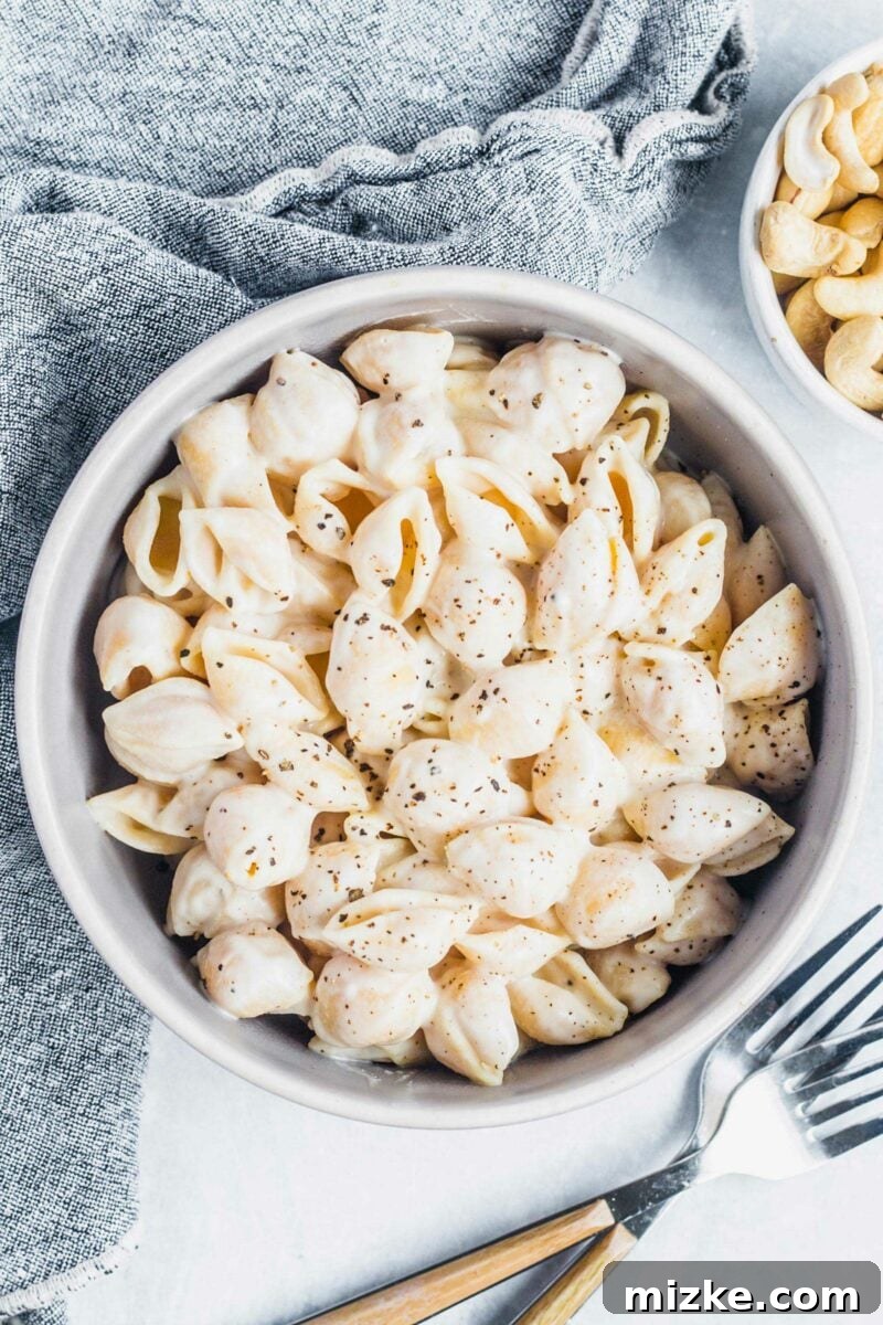 Velvety Vegan Pasta Shells 2 A bowl of creamy pasta shells are topped off with fresh cracked black pepper, ready to be served.