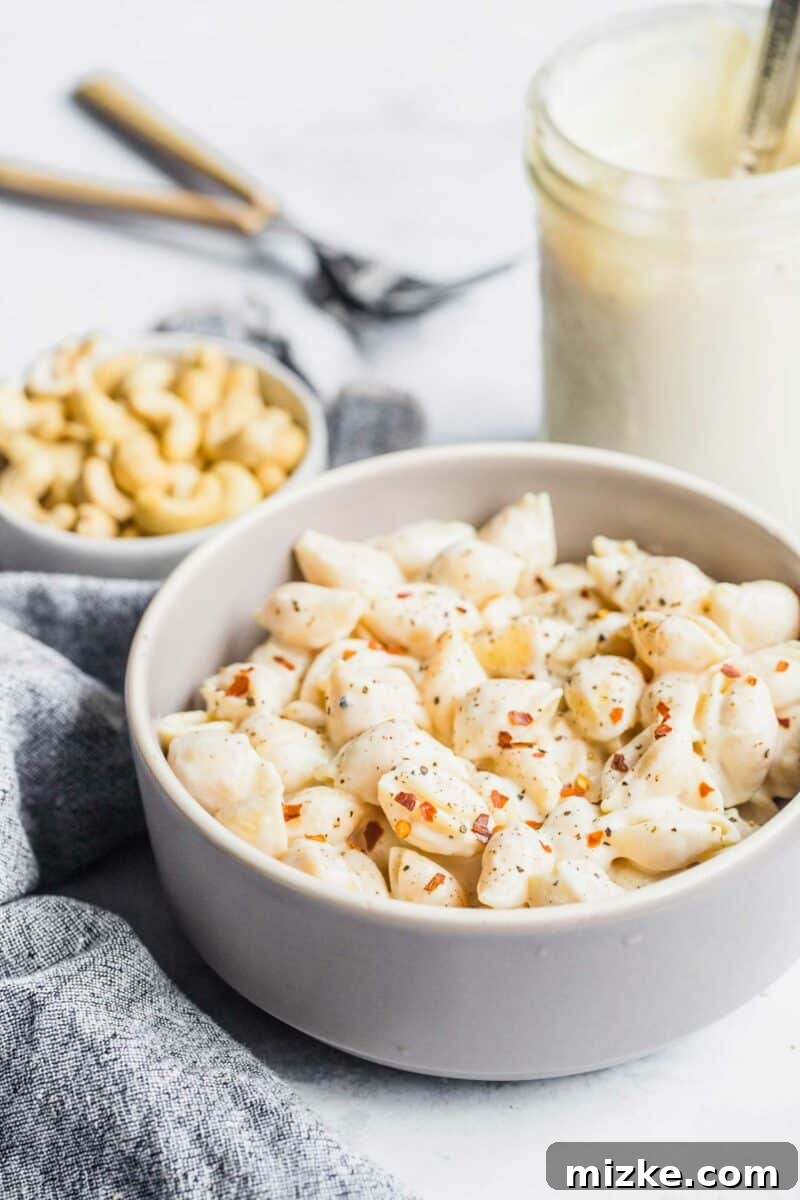 Velvety Vegan Pasta Shells 4 A pristine white bowl holds a generous serving of vegan creamy pasta shells, perfectly seasoned and ready to enjoy.