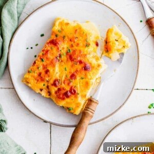A close-up of the finished scalloped potatoes, garnished with fresh herbs.