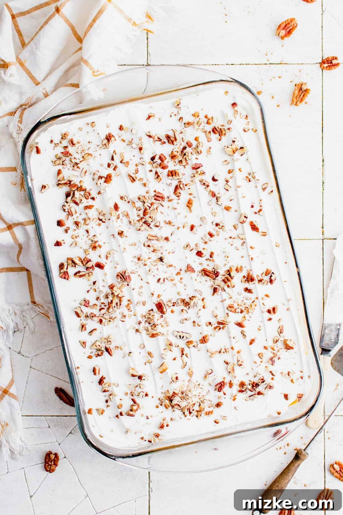 The perfect finishing touch: crunchy chopped pecans atop a luscious Pumpkin Delight. Crushed pecans are sprinkled across the top of whipped cream in a baking dish.