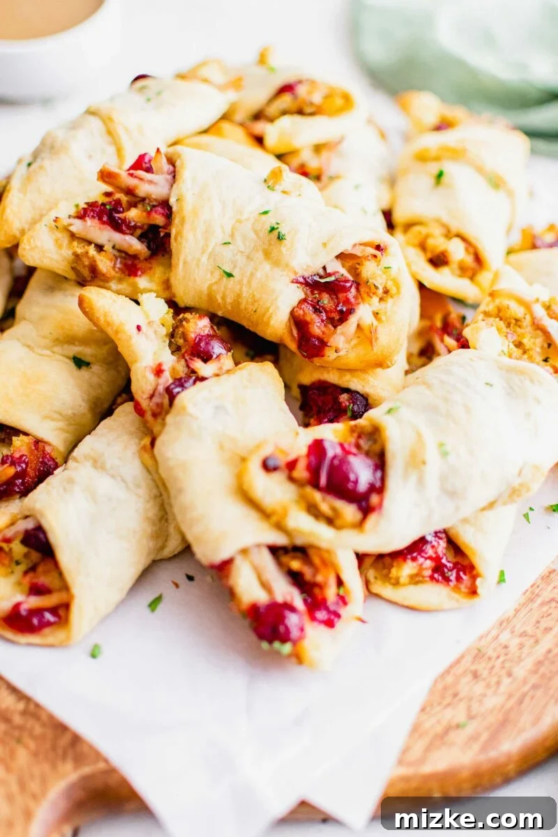 Holiday Feast Pockets 3 A stack of Thanksgiving in a blanket rolls are presented on a sheet of parchment paper.