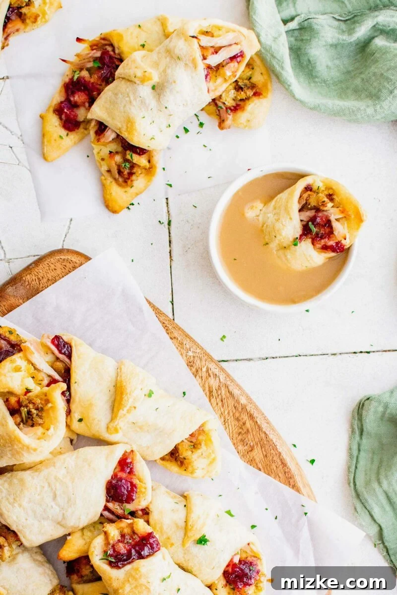 Holiday Feast Pockets 6 A serving of thanksgiving in a blanket appetizers are presented on a white surface with gravy.