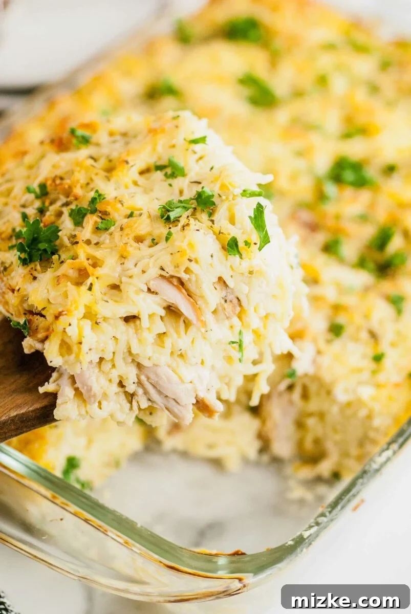 Creamy Turkey Tetrazzini 4 A serving of tetrazzini is being lifted from a large serving dish with a spatula, showing the creamy noodles and turkey.