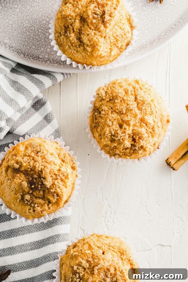 Golden Spiced Sweet Potato Muffins 2 Several soft and fluffy homemade sweet potato muffins are beautifully presented on a clean white surface, highlighting their golden-brown tops and inviting texture.