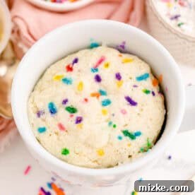 Cooked funfetti mug cake in a white mug, fluffy and ready