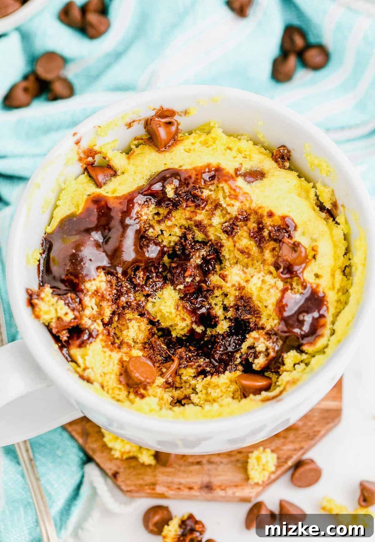 Instant Chocolate Chip Mug Treat 2 Delicious chocolate chip mug cake with extra chocolate chips scattered in the background