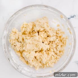 Cookie dough is in a glass bowl, prepared for the next step.