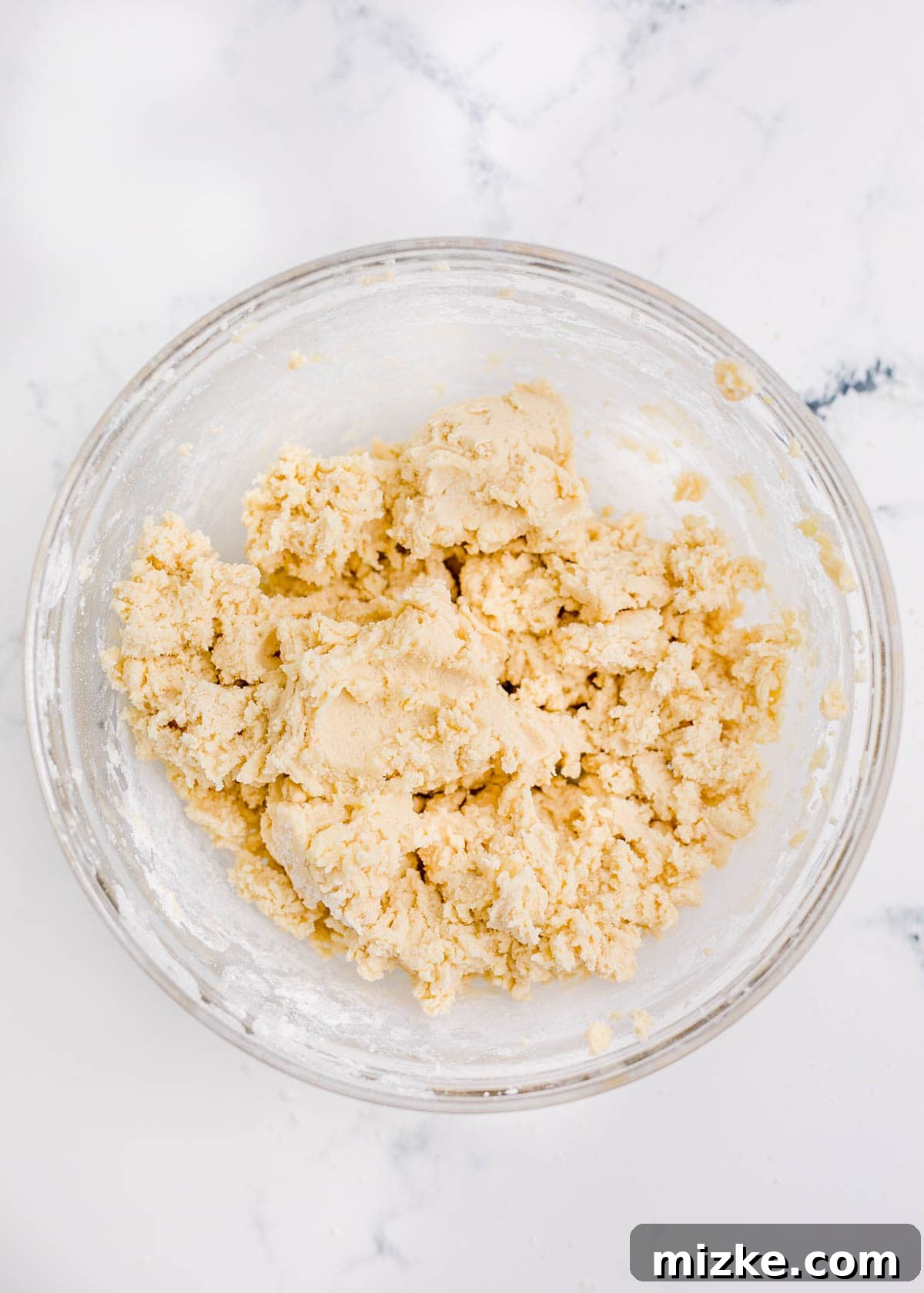 Cookie dough is in a glass bowl, ready to be shaped.