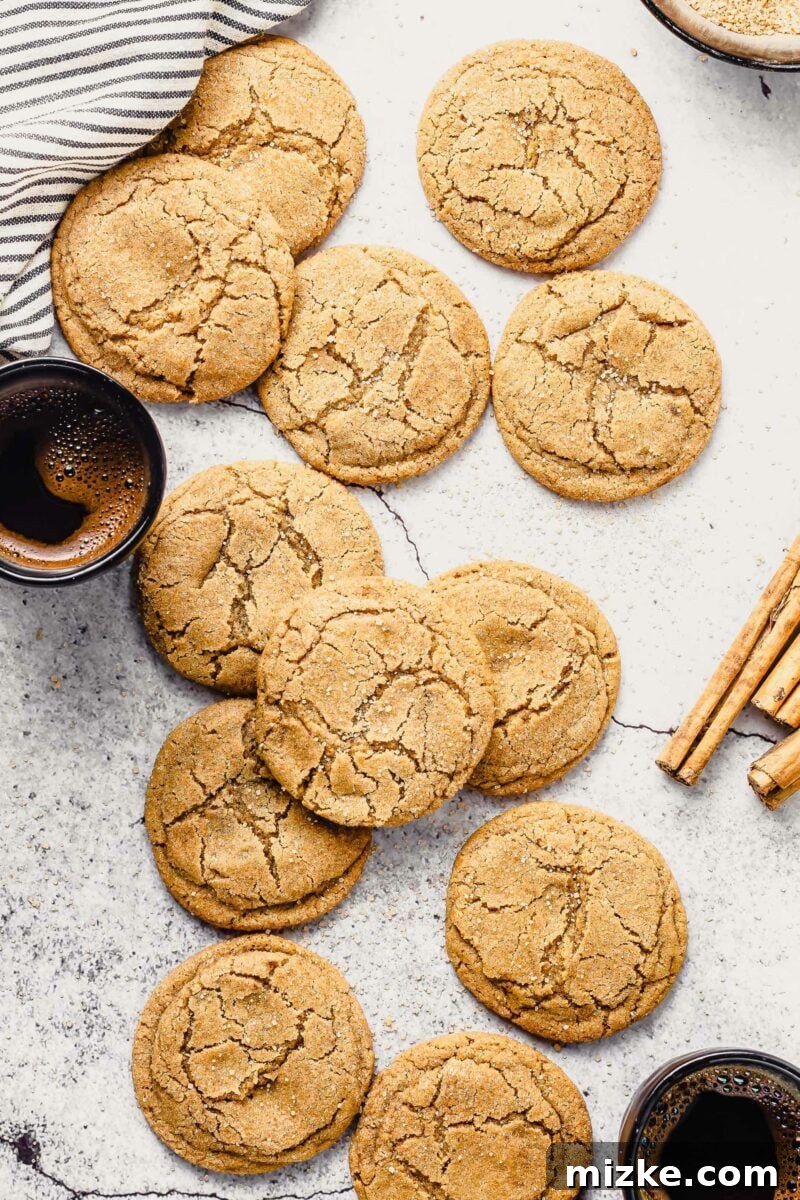 Warm Cinnamon Brown Sugar Delights 2 A batch of homemade cookies are presented on a white countertop next to cinnamon sticks.