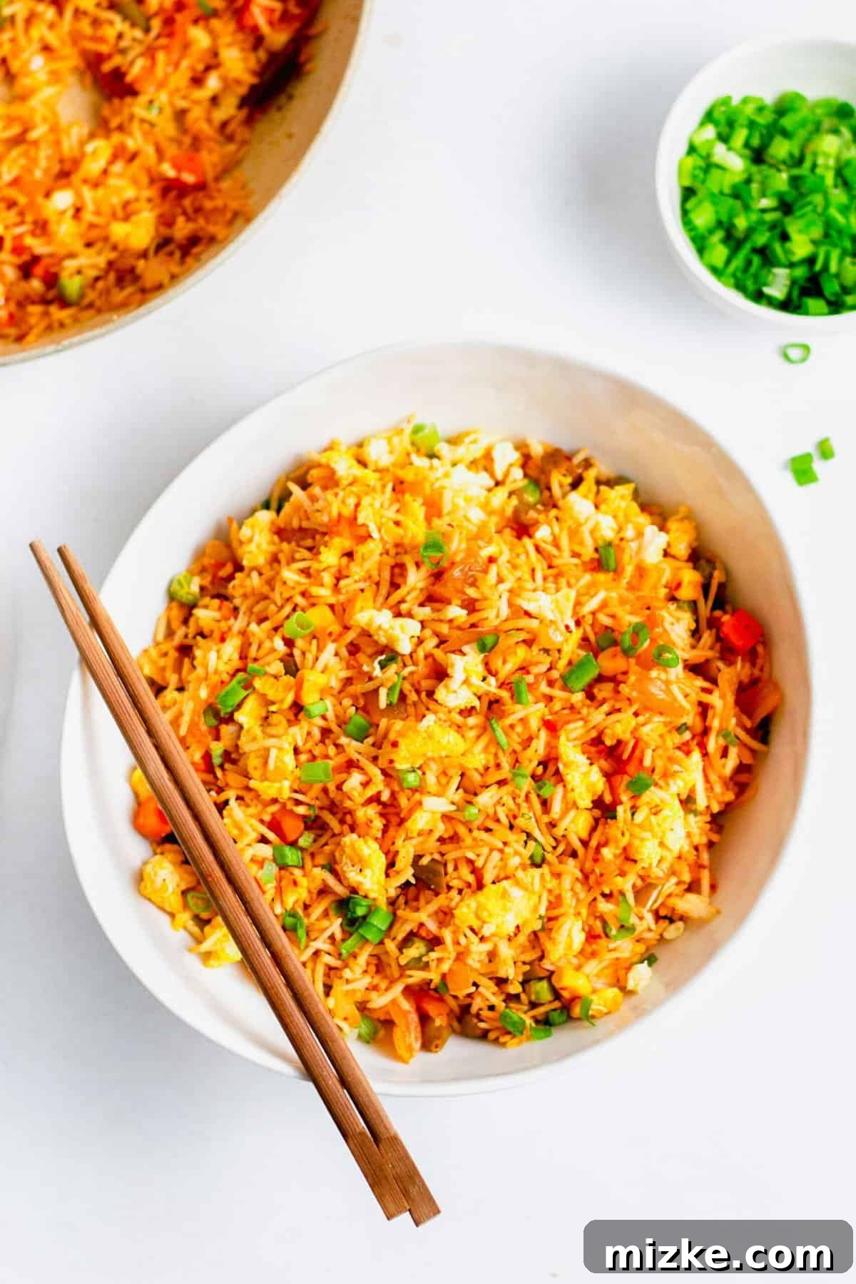 Sizzling Kimchi Fried Rice 2 Overhead view of kimchi fried rice in white bowl with wooden chopsticks