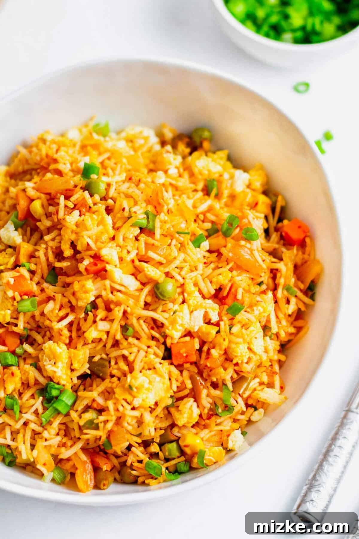 Sizzling Kimchi Fried Rice 5 Kimchi fried rice in white bowl, garnished with green onions