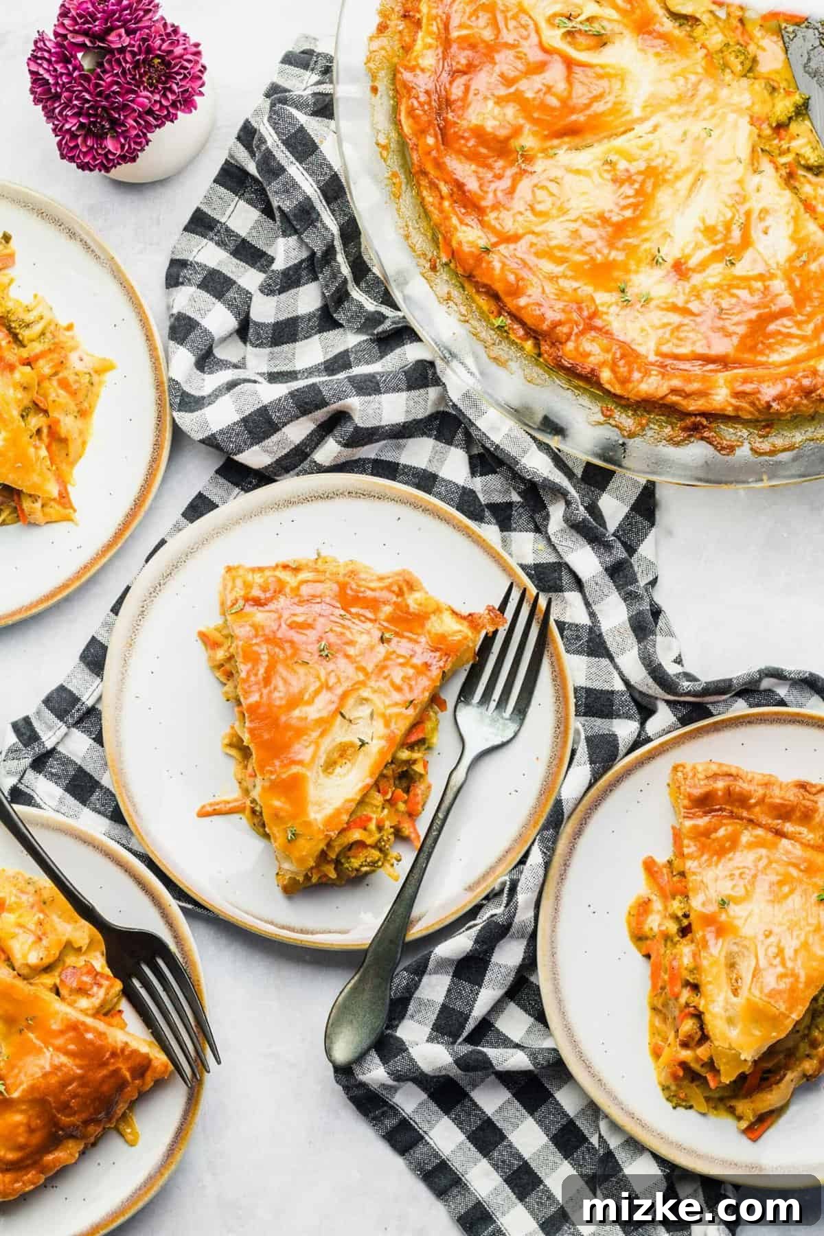 Golden-Baked Cheesy Chicken & Broccoli Pot Pie 4 Overhead view of two slices of cheesy broccoli chicken pot pie on plates, ready to serve