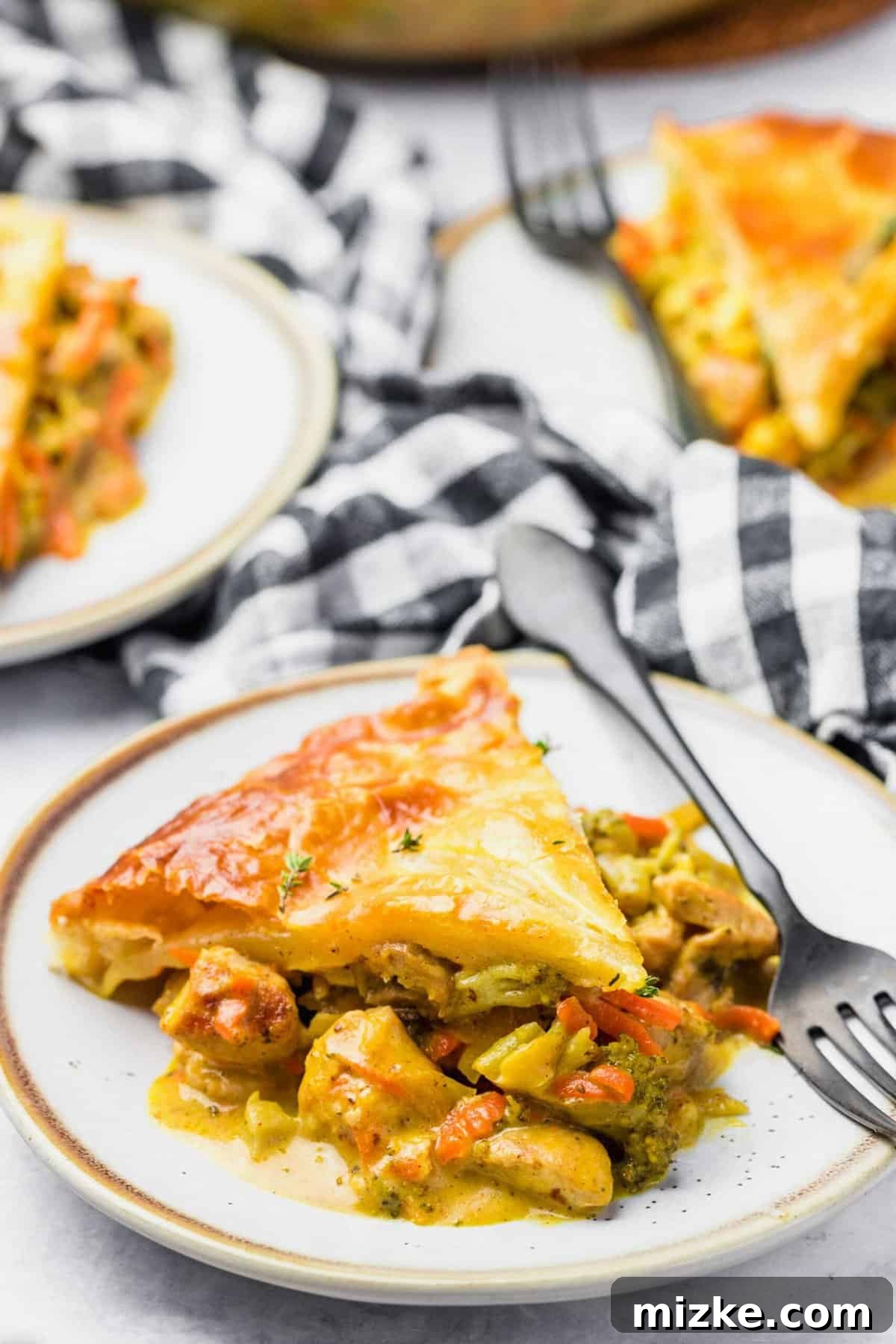 Golden-Baked Cheesy Chicken & Broccoli Pot Pie 6 A perfectly portioned slice of Cheesy Broccoli Chicken Pot Pie on a plate with a fork, showing the rich filling and flaky crust