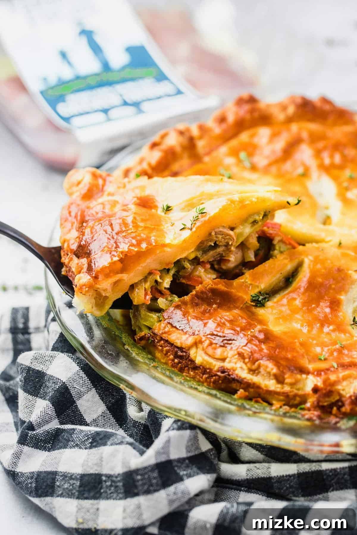 Golden-Baked Cheesy Chicken & Broccoli Pot Pie 7 A slice of pot pie being carefully removed from the baking dish with a serving utensil