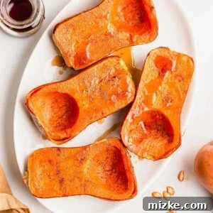 Roasted honeynut squash halves on a white serving platter, beautifully caramelized and ready to be enjoyed as a perfect fall side dish.