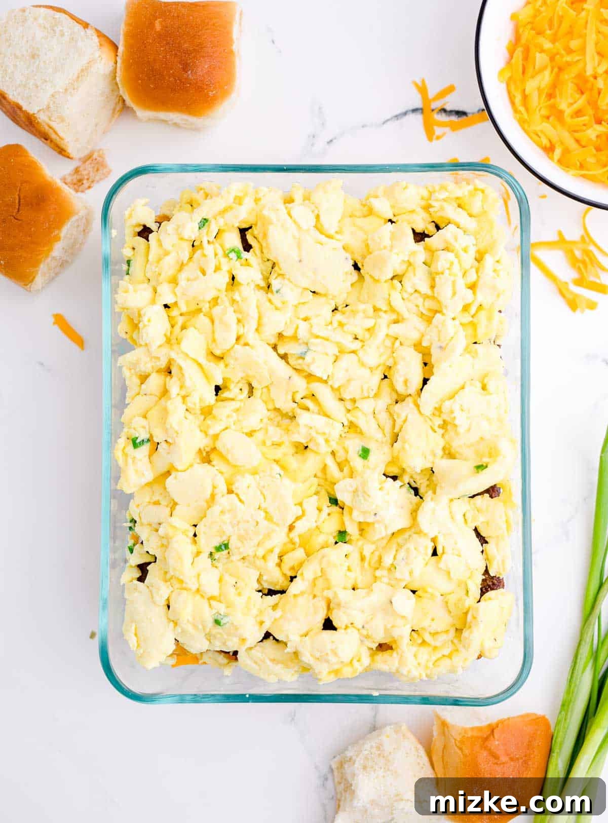 Morning Bites 13 Fluffy scrambled eggs layered over the cooked sausage in a glass baking dish, forming the next delicious layer