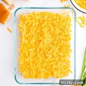 Shredded cheddar cheese in a glass baking dish