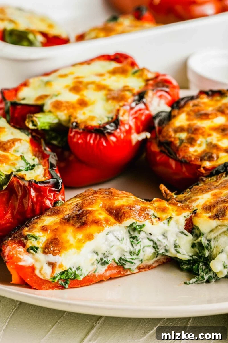 A vibrant red bell pepper has been neatly halved, revealing its irresistibly cheesy, perfectly baked stuffed center, highlighting the rich filling.