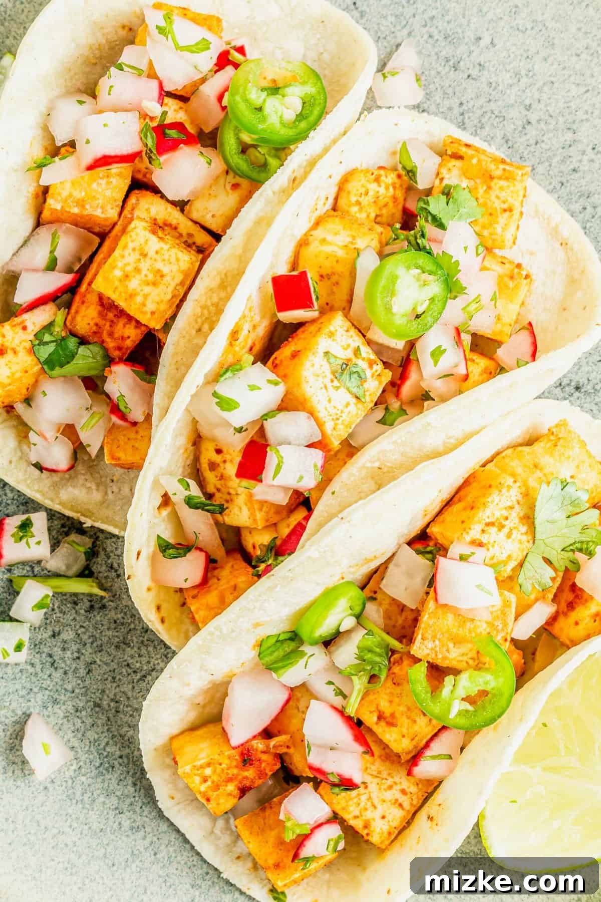 Streetwise Tofu Tacos 3 Three tofu street tacos garnished with jalapenos, radishes, and onions