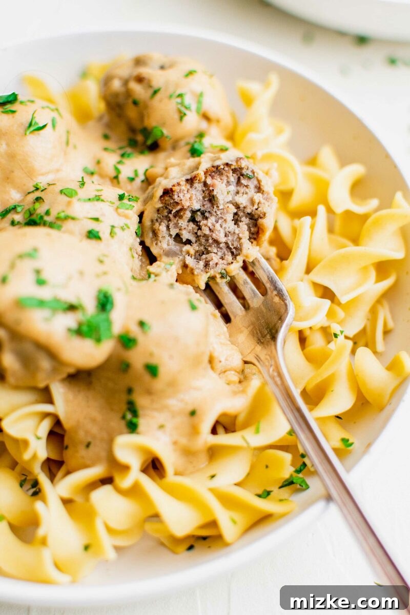 Irresistible Swedish Meatballs 6 A succulent meatball, cut in half, reveals its perfectly cooked, juicy center, inviting a taste of its rich flavors.