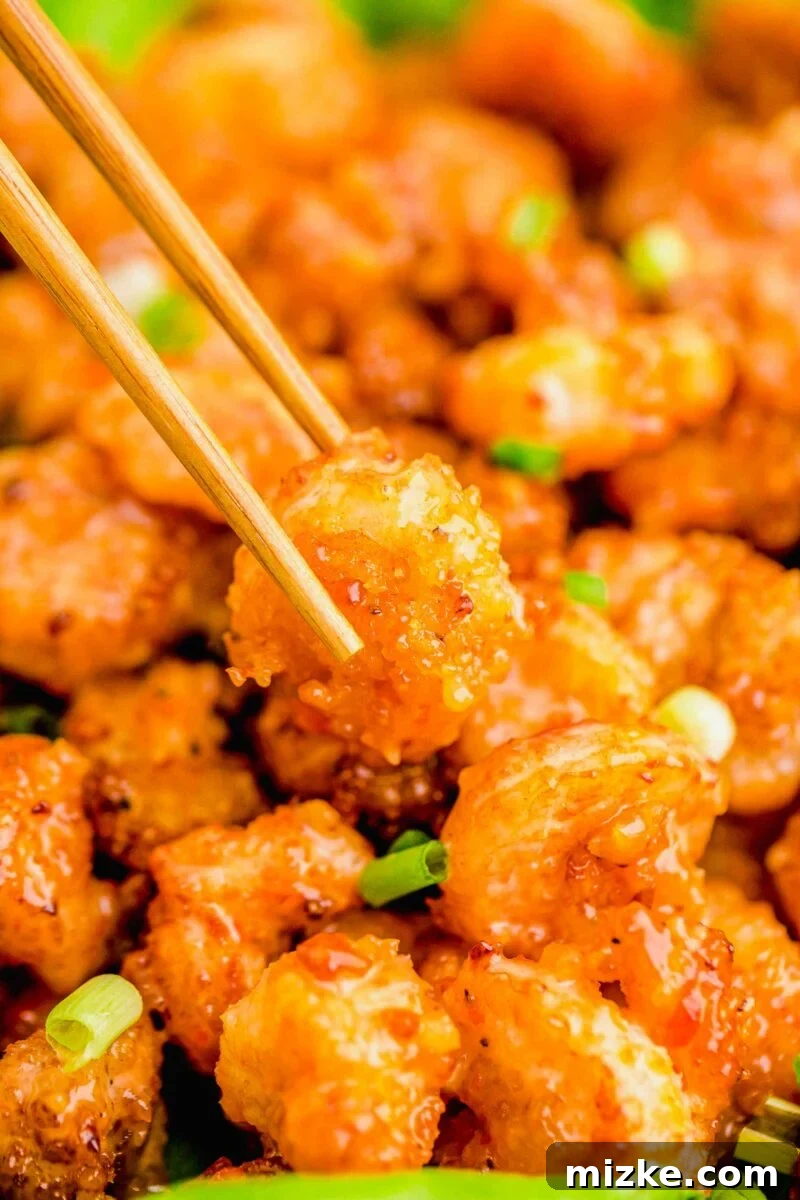 Dynamite Shrimp 14 A bang bang shrimp is being lifted from the batch with chopsticks.