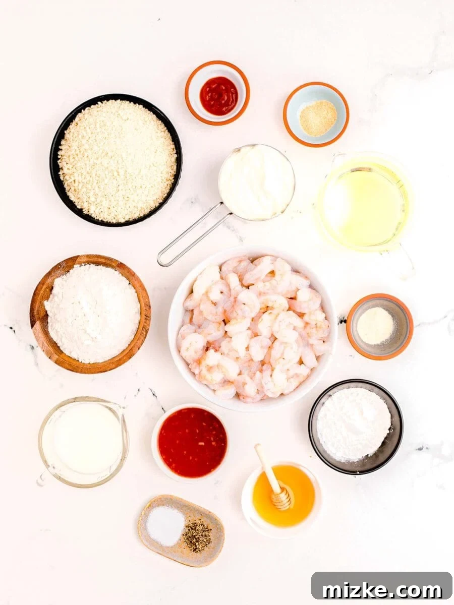 Dynamite Shrimp 4 overhead image of bang bang shrimp ingredients: sriracha, garlic powder, oil, onion powder, cornstarch, honey, salt and pepper, sweet chili sauce, buttermilk, flour, panko breadcrumbs, mayo and raw shrimp