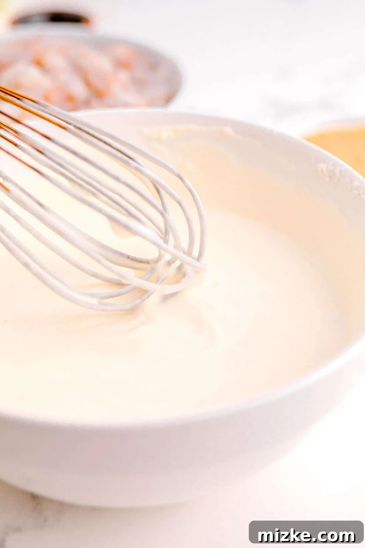 Dynamite Shrimp 6 buttermilk, cornstarch, and flour mixture being whisked together in a white bowl
