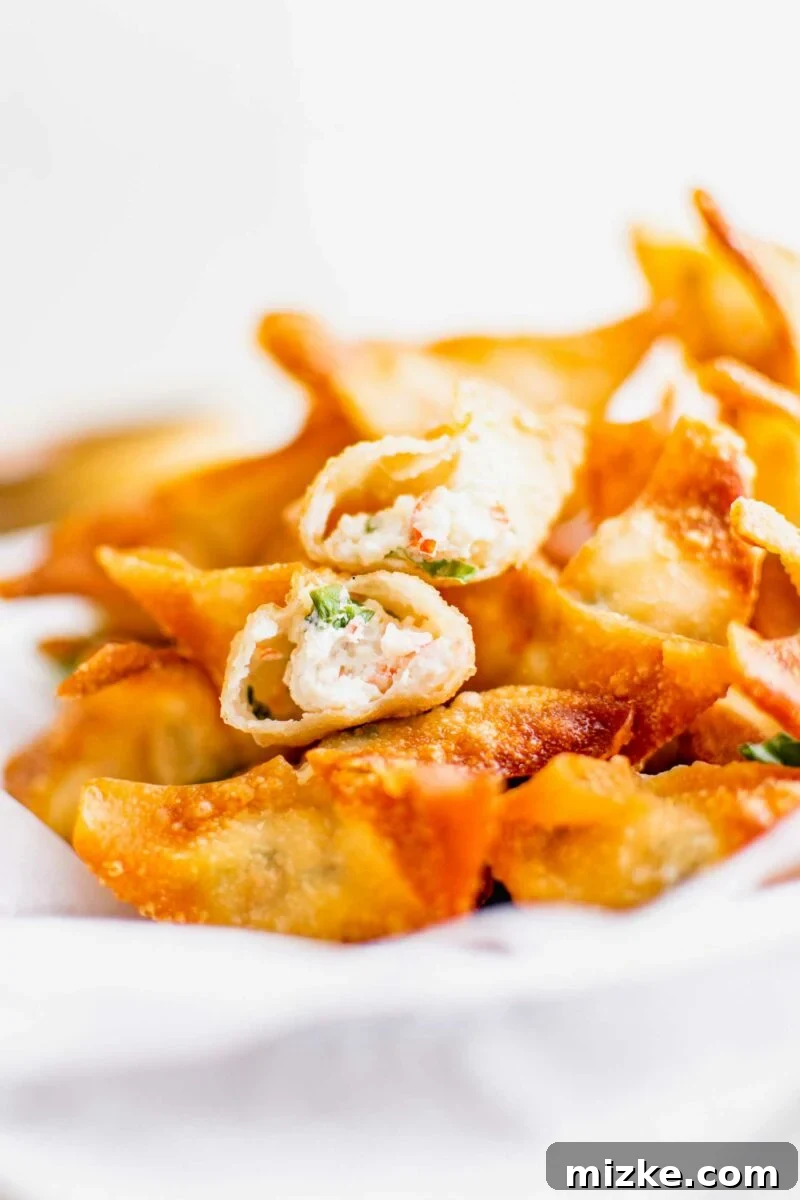 Golden Crispy Crab Bites 12 A single crab rangoon has been carefully split in the middle to reveal its creamy, cooked center, inviting diners to savor its delicious filling.