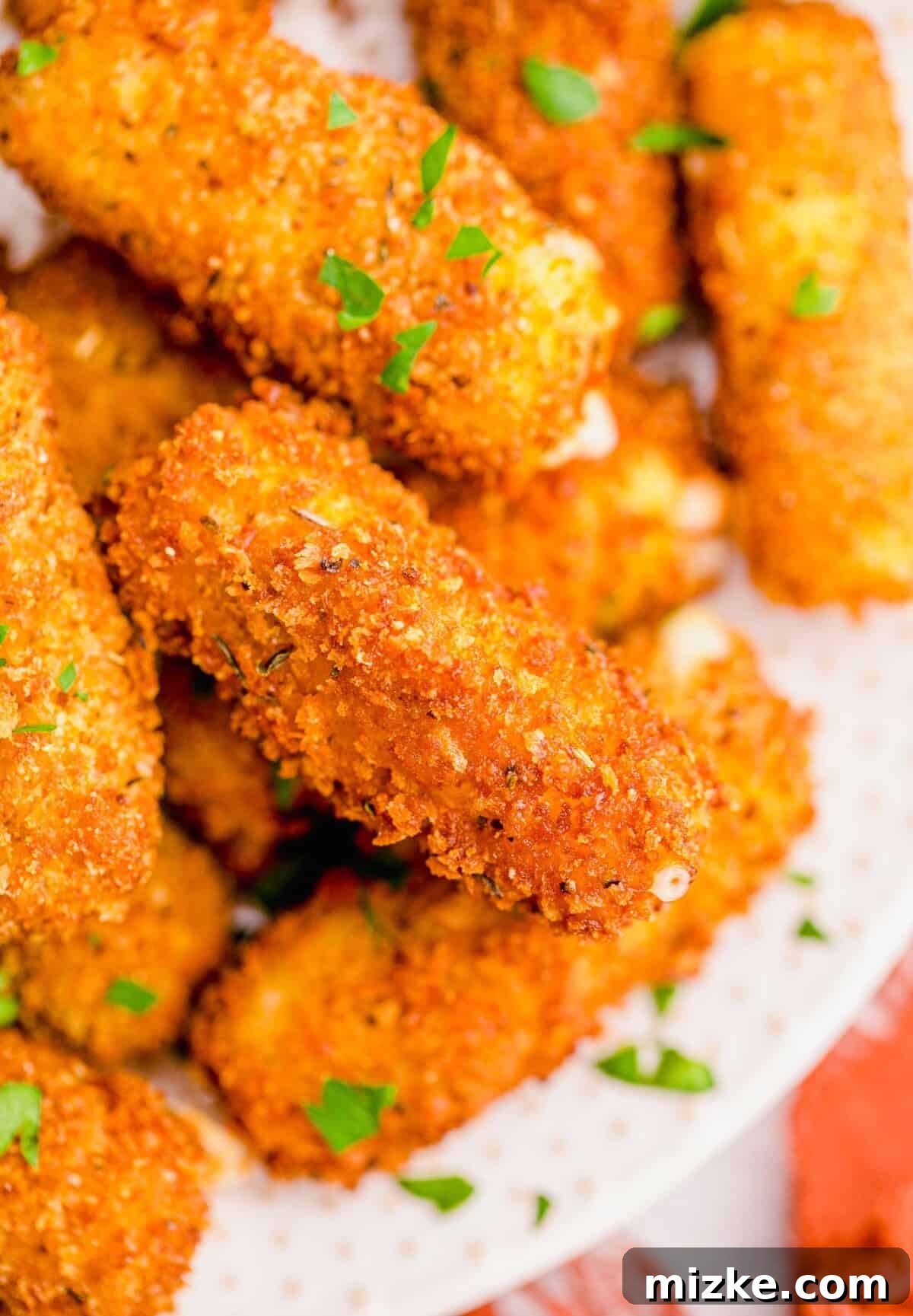 Irresistible Homemade Mozzarella Sticks 12 close-up image of fried mozzarella stick showing the browned breading