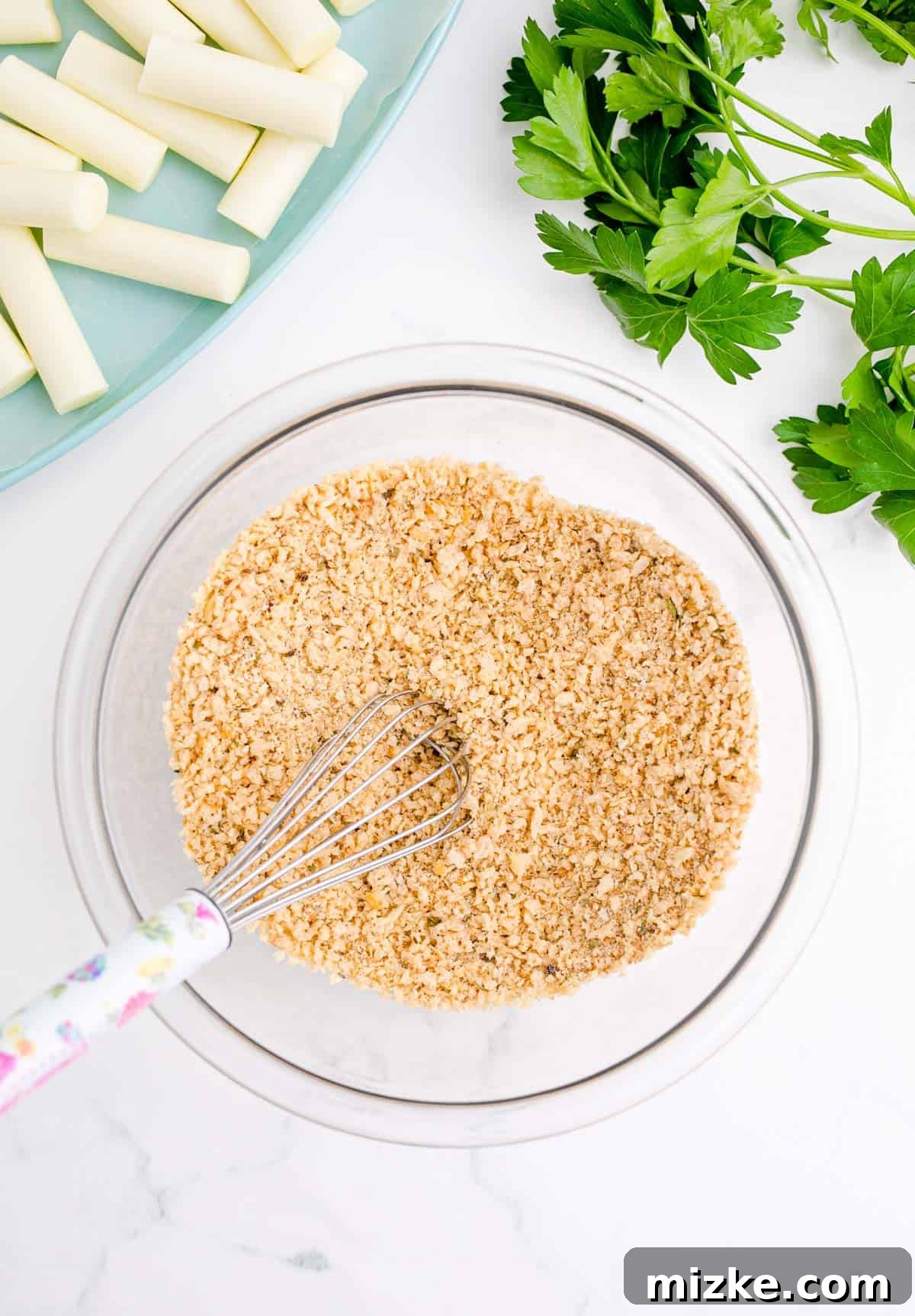 Irresistible Homemade Mozzarella Sticks 4 whisking breadcrumbs and panko breadcrumbs together in a clear bowl