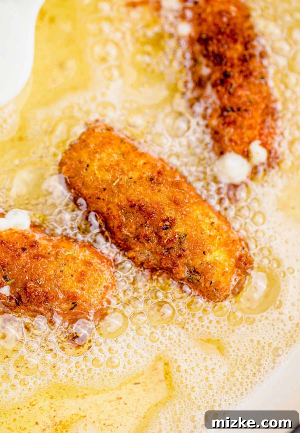 Irresistible Homemade Mozzarella Sticks 9 fried mozzarella stick in bubbling hot oil