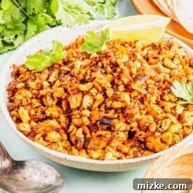 Bowl of tofu chorizo with cilantro leaves and lime wedge