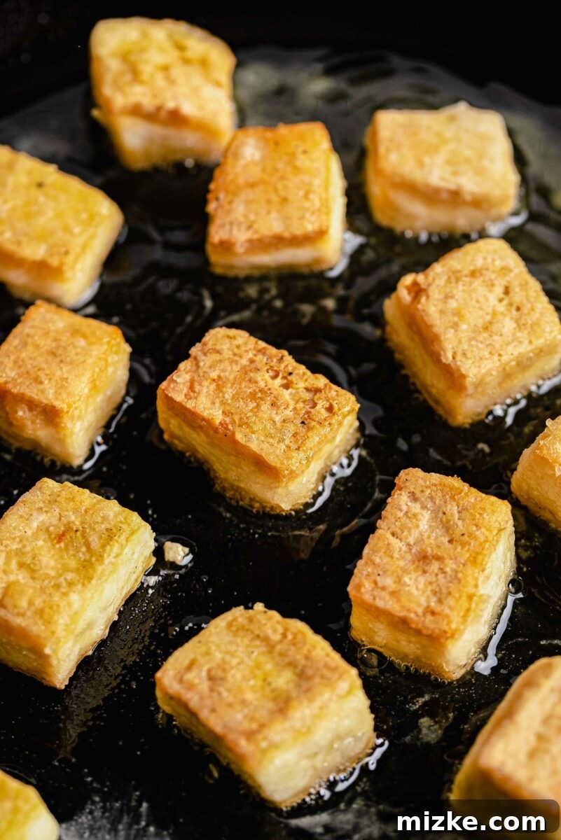 Beyond Bland: Unlock Tofu's Flavor Secrets 8 Crispy cubes of tofu perfectly fried and ready to be sauced or served