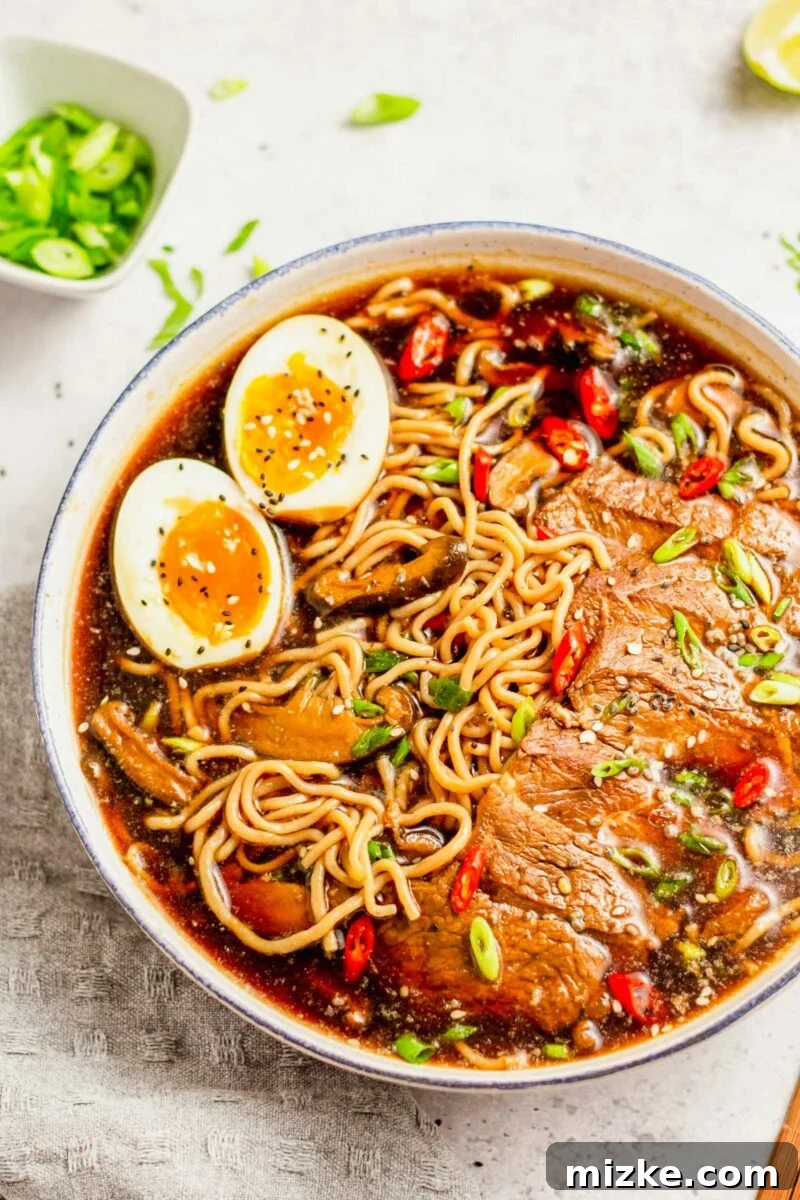 Beef Ramen Bliss 6 A comforting bowl of beef ramen noodle soup, artfully garnished with a sprinkle of black and white sesame seeds, ready for enjoyment.