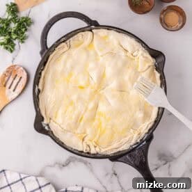 Velvety Chicken Alfredo Pot Pie 12 Egg wash brushed on top of puff pastry in a cast iron skillet before baking.
