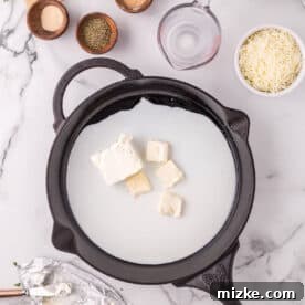 Velvety Chicken Alfredo Pot Pie 8 Milk, butter, and cream cheese melting together in a cast iron skillet.