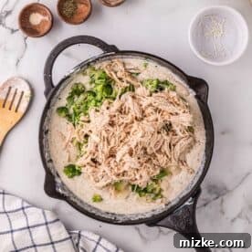 Velvety Chicken Alfredo Pot Pie 10 Broccoli, potatoes, and shredded chicken added to the alfredo mixture in a cast iron skillet.