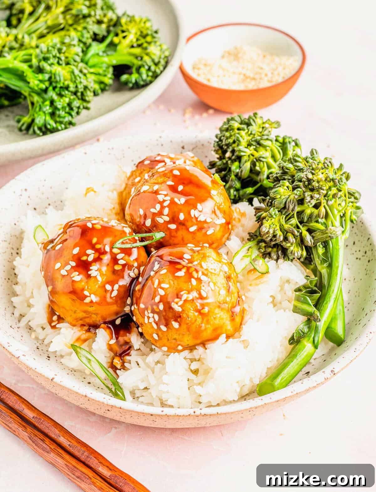 A wholesome and flavorful teriyaki tofu meatball bowl. A beautifully plated bowl of jasmine rice topped with three teriyaki tofu meatballs and spears of vibrant steamed broccoli.