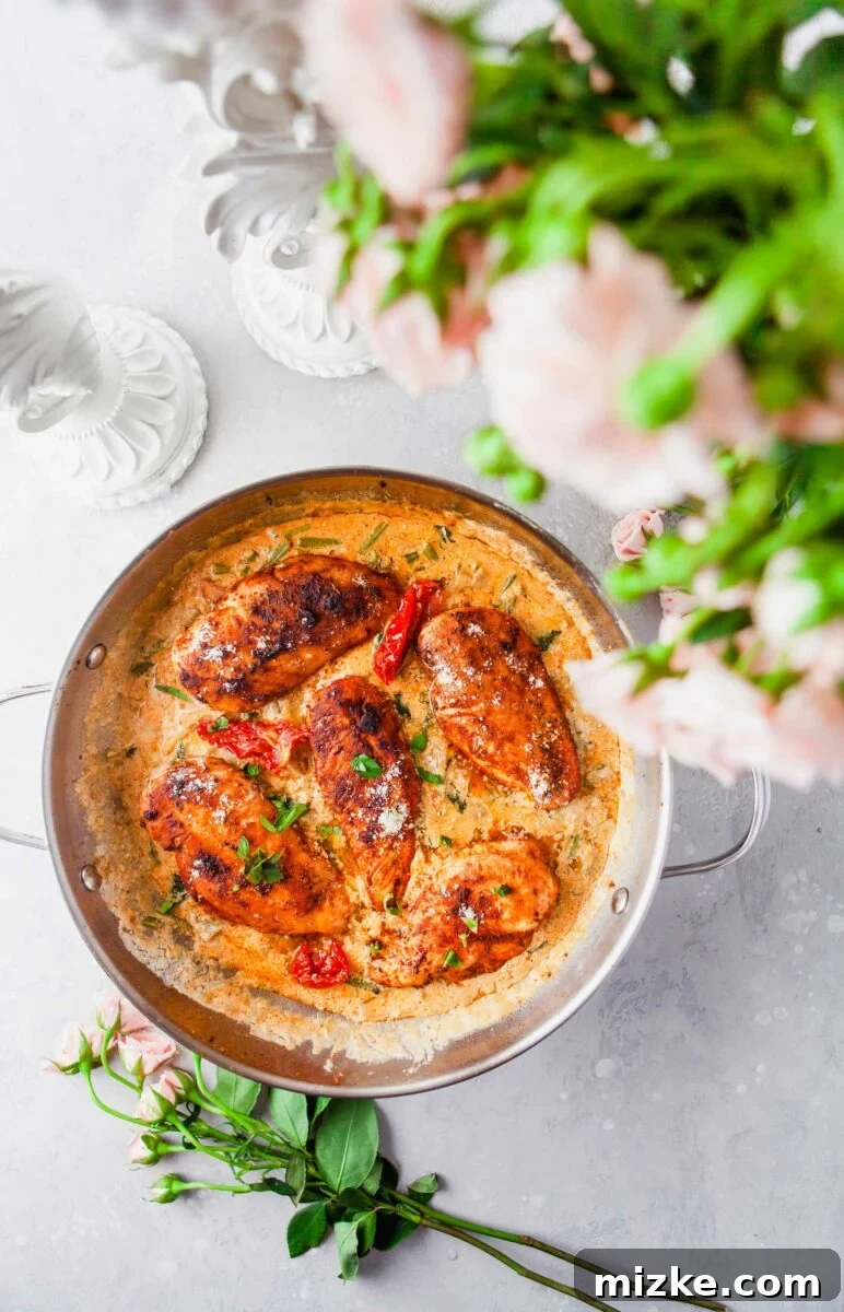 Velvety Tuscan Chicken 3 Five pieces of perfectly cooked creamy Tuscan chicken garnished with fresh parsley in a cast iron skillet.