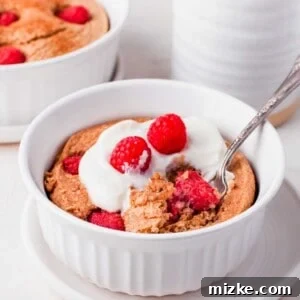 Raspberry Oatmeal Bake 7 Raspberry baked oatmeal topped with yogurt and fresh raspberries, served in a white bowl with a spoon