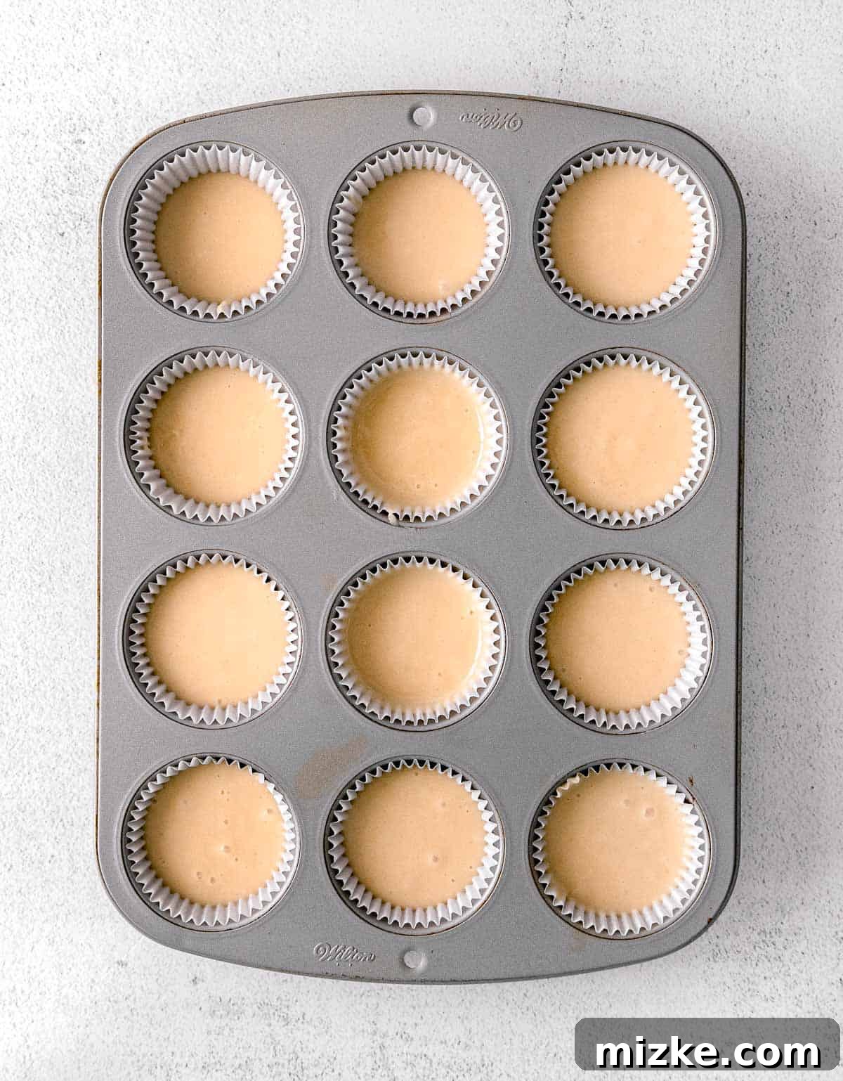 Blossom Honey Lavender Cupcakes 5 Cupcake batter neatly portioned into a 12-cup muffin tin, lined with paper cases, before baking.