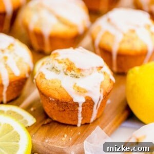 A close-up of a beautifully baked and glazed Lemon Poppyseed Muffin.