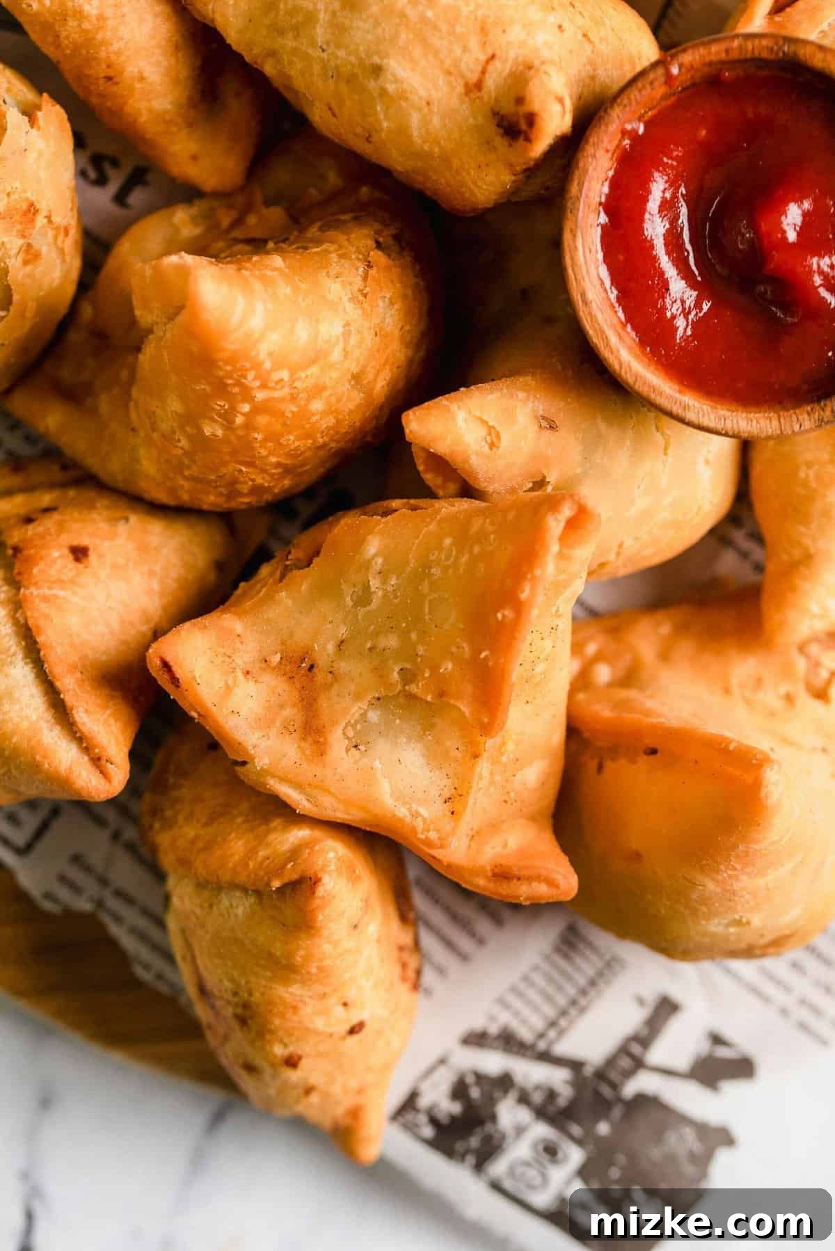 Golden Crispy Vegetable Samosas 5 Platter of crispy vegetable samosas served with a vibrant green dipping sauce in a small bowl, ready for enjoyment.