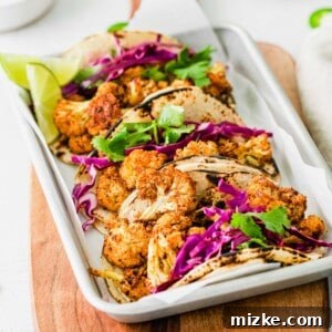 A close-up shot of an assembled vegan cauliflower taco, showing the roasted cauliflower, slaw, and lime crema, ready for enjoyment.