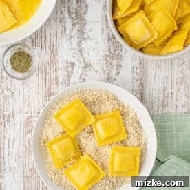 egg washed ravioli sits on top of a panko breadcrumb mixture