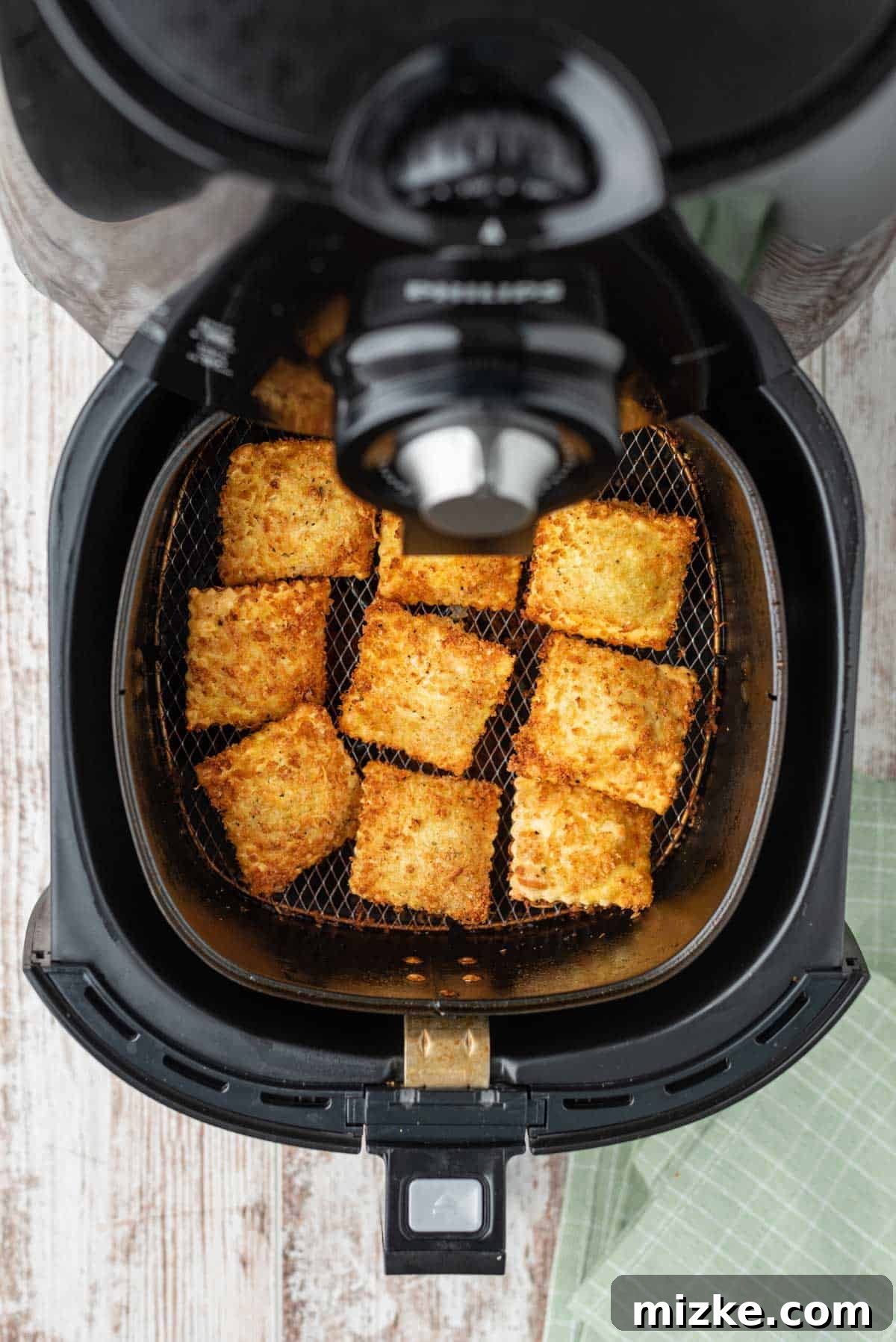 Air Fryer Toasted Ravioli 8 The air fryer basket displays a batch of perfectly browned and exceptionally crispy air fried ravioli, indicating they are fully cooked and ready to be enjoyed.