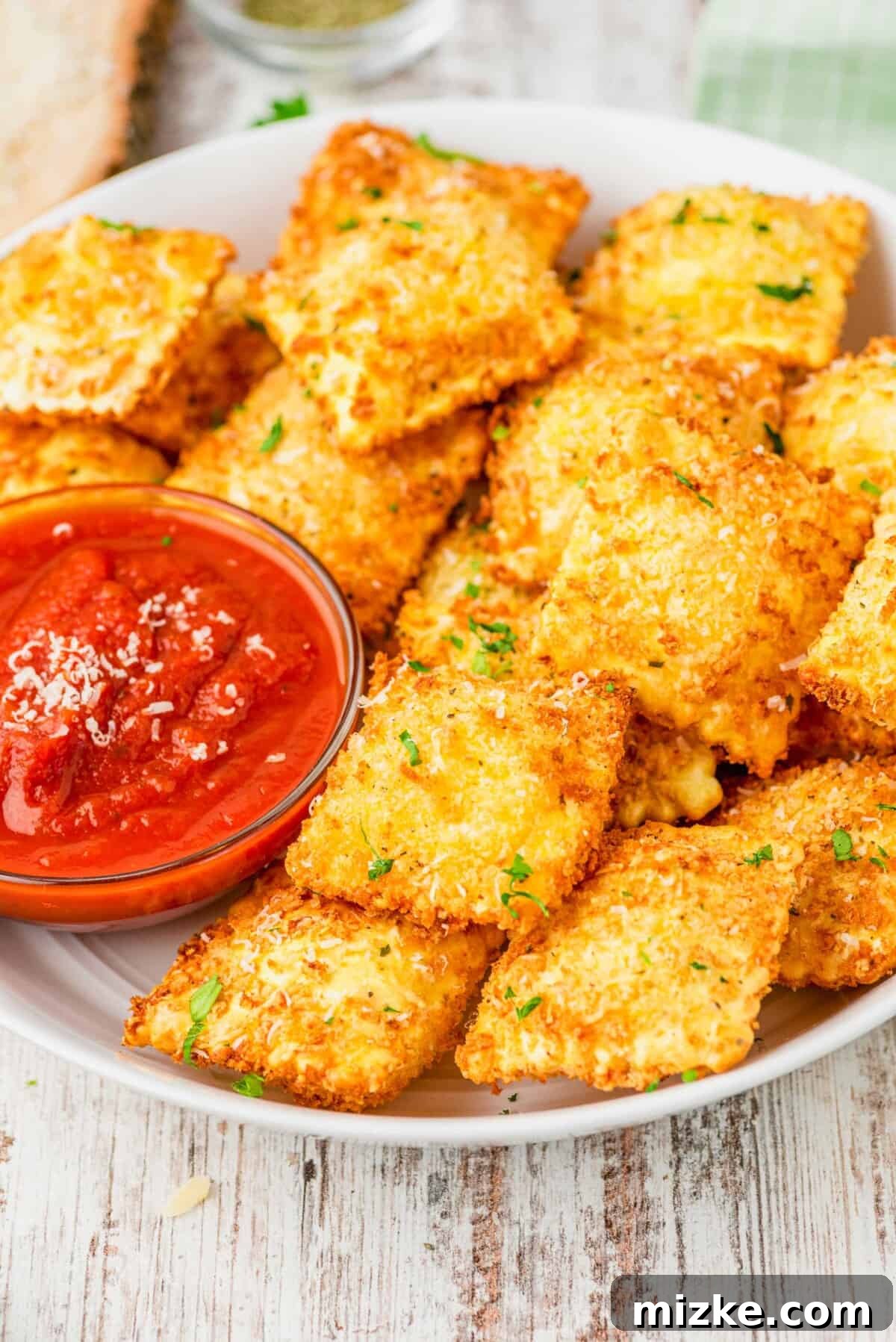 Crispy air fryer ravioli served in a bowl with marinara sauce for dipping